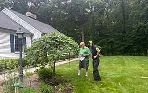 Two Ecolawn team members looking over a customer's lawn and garden beds